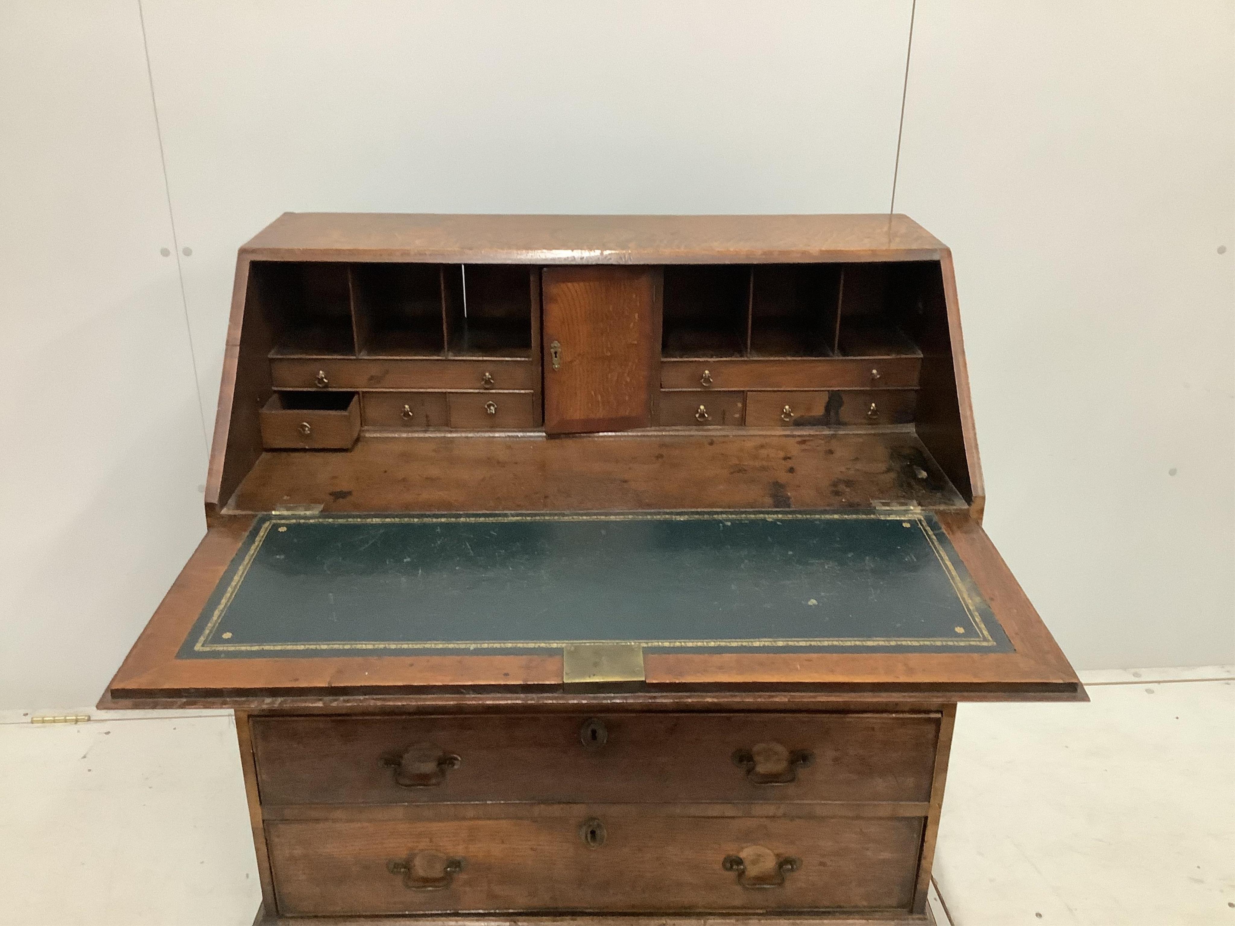 A George III oak bureau, with four long graduated drawers, on bracket feet, width 92cm, depth 50cm, height 100cm. Condition - fair